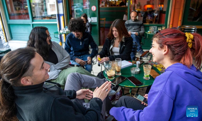 People spend time at a local cafe in downtown Athens, Greece, on April 11, 2023. Meeting over a cup of coffee has long been an integral part of Greek culture. However, the inflationary pressure of the past year has forced 54 percent of coffee lovers to cut back on their caffeine habit, a recent survey conducted for the Hellenic Coffee Association has found.(Photo: Xinhua)