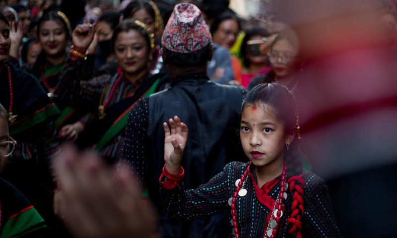 A girl in traditional attire participates in a chariot procession held to mark the Rato Machindranath festival in Lalitpur, Nepal, May 8, 2023. Rato Machindranath is known as the god of rain and both Hindus and Buddhists worship Machindranath for good rain to prevent drought during the rice harvest season. (Photo by Sulav Shrestha/Xinhua)