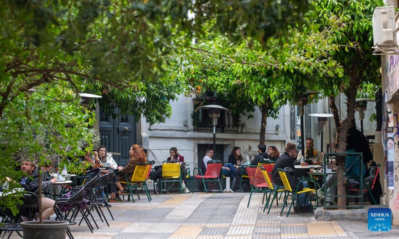 People spend time at a local cafe in downtown Athens, Greece, on April 11, 2023. Meeting over a cup of coffee has long been an integral part of Greek culture. However, the inflationary pressure of the past year has forced 54 percent of coffee lovers to cut back on their caffeine habit, a recent survey conducted for the Hellenic Coffee Association has found.(Photo: Xinhua)