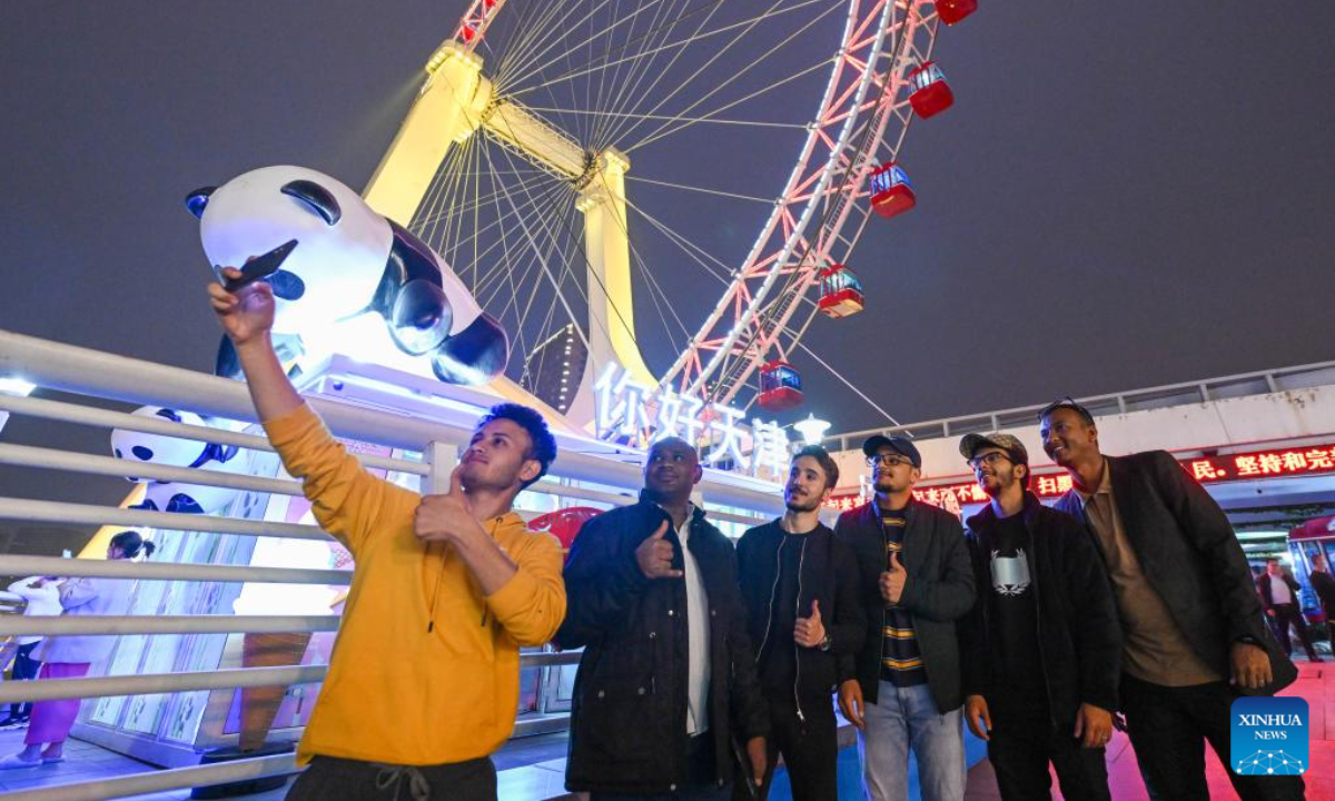 International students from Beijing Institute of Technology take photos before taking the Tientsin Eye Ferris wheel, in north China's Tianjin, April 27, 2023. The Tientsin Eye Ferris wheel, also known as the Tianjin Eye, one of the city's landmarks, has been renovated for the upcoming Labor Day holiday. Photo:Xinhua