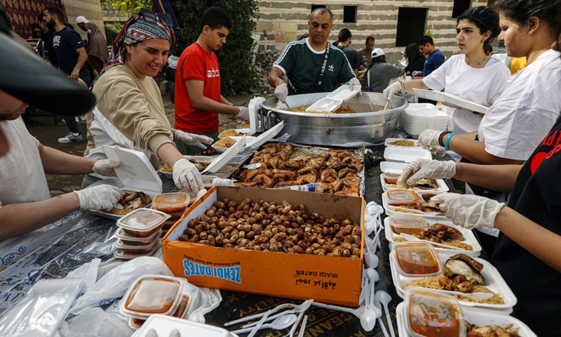Volunteers pack iftar meals outside of the Al-Rahman charity kitchen in Cairo, Egypt, on April 9, 2023. Dozens of volunteers of different ages were busy cooking, packing and preparing meal boxes as their charity kitchen distributes thousands of free meals every day across the capital Cairo during the Muslim holy month of Ramadan.(Photo: Xinhua)