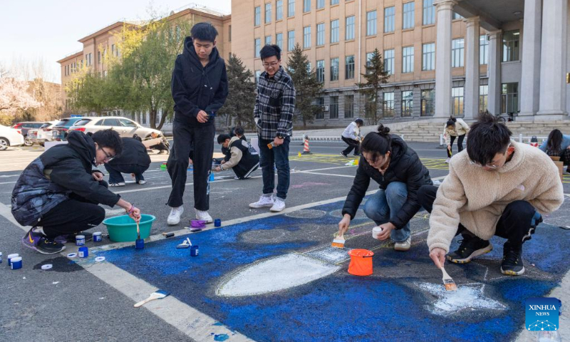 Students paint with the theme of space on the ground at Harbin Institute of Technology in Harbin, capital of northeast China's Heilongjiang Province, on April 22, 2023. Activities are held in Harbin Institute of Technology to celebrate the upcoming Space Day of China, which falls on April 24. (Xinhua/Xie Jianfei)