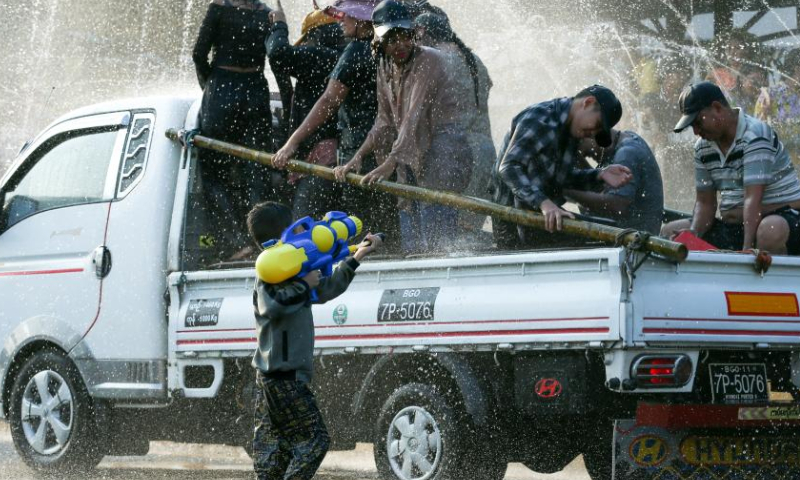 People spray water to celebrate the water festival in Yangon, Myanmar, April 15, 2023. (Photo by Myo Kyaw Soe/Xinhua)