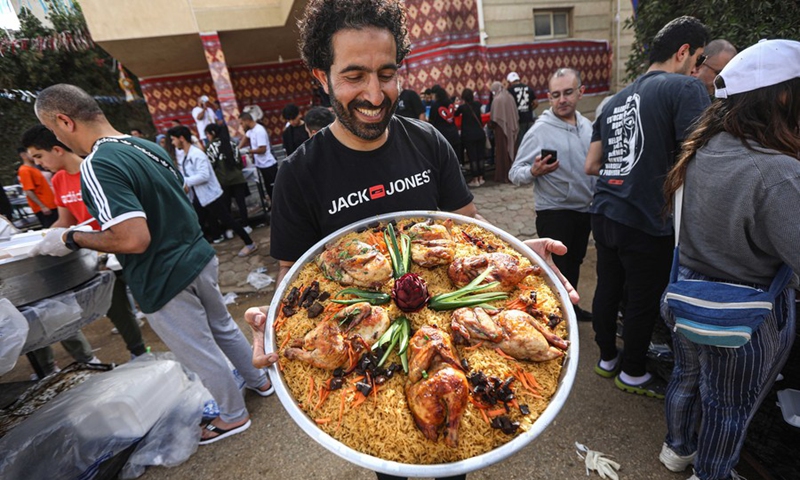 A volunteer shows ready-made iftar meals outside of the Al-Rahman charity kitchen in Cairo, Egypt, on April 9, 2023.(Photo: Xinhua)