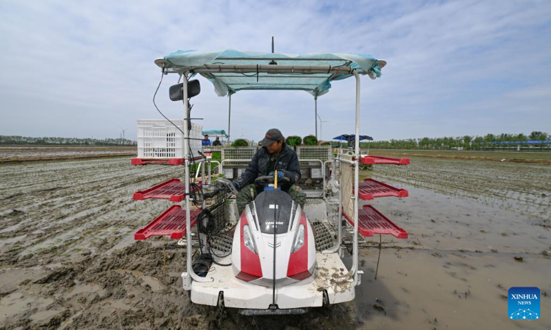 A farmer sets the working route of a transplanter at an agricultural products development and demonstration center in north China's Tianjin, May 5, 2023. (Xinhua/Sun Fanyue)