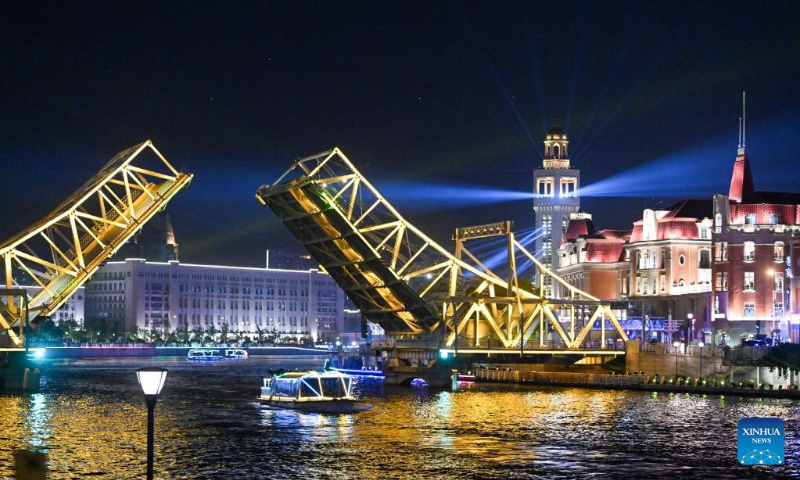 A boat sails past the opened Jiefang Bridge in Tianjin, north China, May 1, 2023. The landmark bridge opened on Monday at a maximum angle of 60 degrees. (Xinhua/Sun Fanyue)