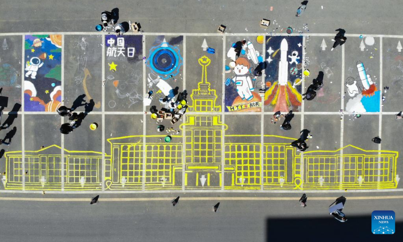 This aerial photo taken on April 22, 2023 shows students painting with the theme of space on the ground at Harbin Institute of Technology in Harbin, capital of northeast China's Heilongjiang Province. Activities are held in Harbin Institute of Technology to celebrate the upcoming Space Day of China, which falls on April 24. (Xinhua/Xie Jianfei)