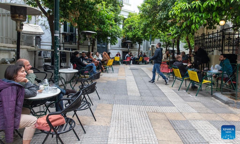 People spend time at a local cafe in downtown Athens, Greece, on April 11, 2023. Meeting over a cup of coffee has long been an integral part of Greek culture. However, the inflationary pressure of the past year has forced 54 percent of coffee lovers to cut back on their caffeine habit, a recent survey conducted for the Hellenic Coffee Association has found.(Photo: Xinhua)