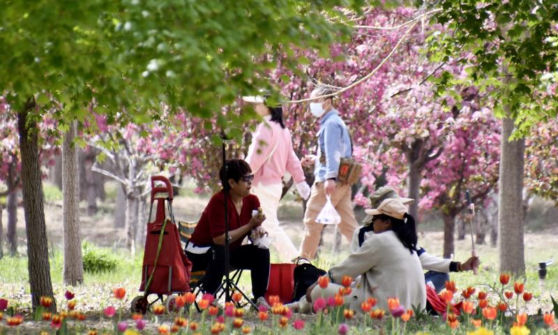 Tourists enjoy the scenery of blooming flowers by Yongding River in Daxing District of Beijing, capital of China, April 15, 2023. Colorful flowers of various species are in full bloom, attracting many tourists to spend their leisure time here. (Xinhua/Li Xin)