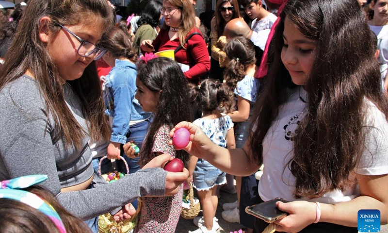 Two girls play egg tapping during the celebration of Easter in the city of Hasbaya, south Lebanon, April 16, 2023.(Photo: Xinhua)