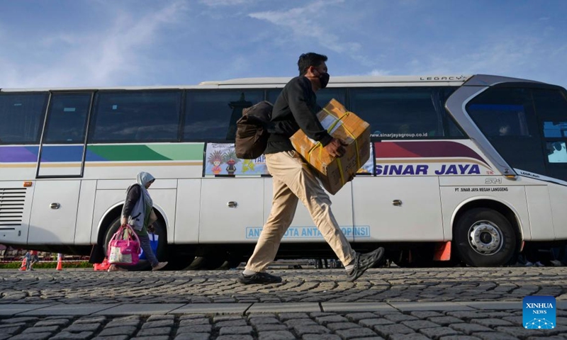 People carry belongings to board free-of-charge buses to their hometowns in Jakarta, Indonesia, April 17, 2023. Indonesia is facing the homecoming season when people from urban cities return to their respective hometowns to celebrate Eid with their families(Photo: Xinhua)