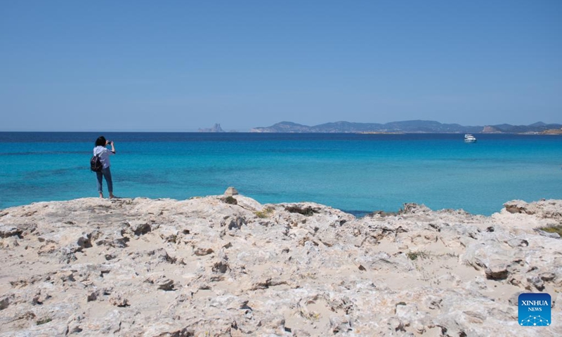 A woman takes photos at the seaside in Formentera Island of the Balearic Islands, Spain, April 11, 2023.(Photo: Xinhua)