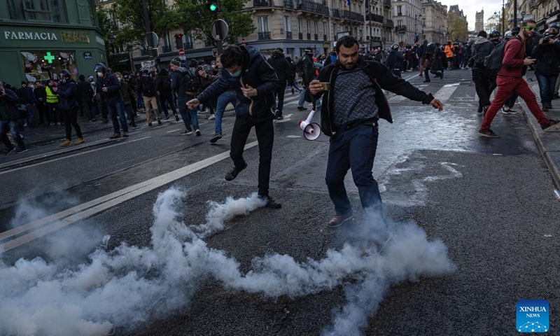 Protesters try to kick back tear gas canisters during a demonstration against a pensions reform plan in Paris, France, on April 13, 2023. Around 380,000 people participated in the 12th nationwide general mobilization organized by the unions against the government's pension reform plan, the French Interior Ministry said on Thursday.(Photo: Xinhua)