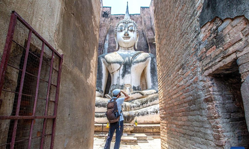 A tourist takes photos at the Historic Town of Sukhothai in Sukhothai, Thailand, April 17, 2023. In 1991, the United Nations Educational, Scientific and Cultural Organization (UNESCO) has inscribed the Historic Town of Sukhothai and Associated Historic Towns on its World Heritage List.(Photo: Xinhua)