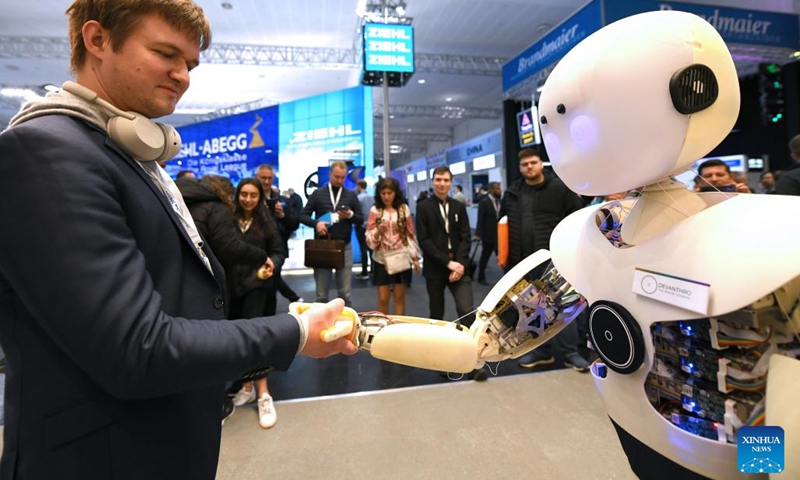 A man shakes hands with an intelligent robot during the Hannover Messe in Hannover, Germany, on April 18, 2023. Germany's leading trade fair for mechanical and electrical engineering kicked off on Monday in Hannover, with the theme of Industrial Transformation - Making the Difference.(Photo: Xinhua)