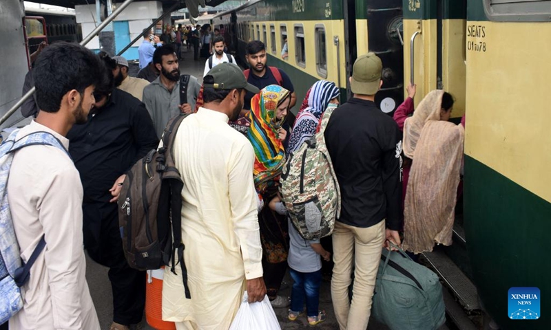 Passengers get on a train at a railway station on the eve of Eid al-Fitr festival in Lahore, Pakistan, April 21, 2023.(Photo: Xinhua)