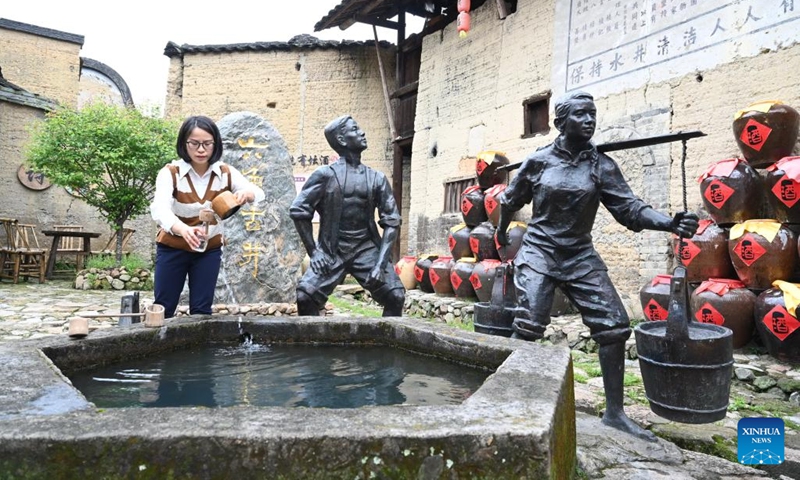 A tourist takes water for drinking from an ancient well that can be used for wine making at Beiqian Village of Daixi Township in Pingnan County, southeast China's Fujian Province, on April 20, 2023. Beiqian Village created a multi-format industry based on the integration of the resources of ancient village, folk culture and yellow wine culture.(Photo: Xinhua)