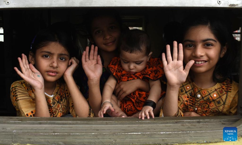 Children wave from a train compartment at a railway station on the eve of Eid al-Fitr festival in Lahore, Pakistan, April 21, 2023.(Photo: Xinhua)