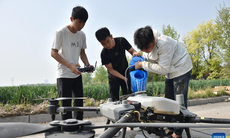 Farmers add pesticide into a plant-protection drone in Zhangxiang Village, Heguo Township of Nanhe District in Xingtai City, north China's Hebei Province, April 19, 2023. As the winter wheat enters the heading stage in central and southern Hebei Province, local agricultural departments have been guiding farmers to carry out wheatland management on time to secure a bumper summer harvest.(Photo: Xinhua)