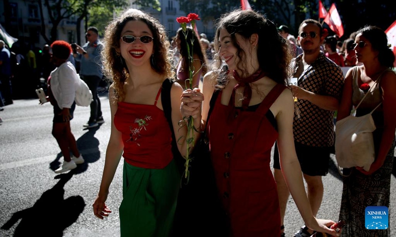 People holding red carnations take part in a parade to mark the 49th anniversary of the Carnation Revolution in Lisbon, Portugal, on April 25, 2023.(Photo: Xinhua)