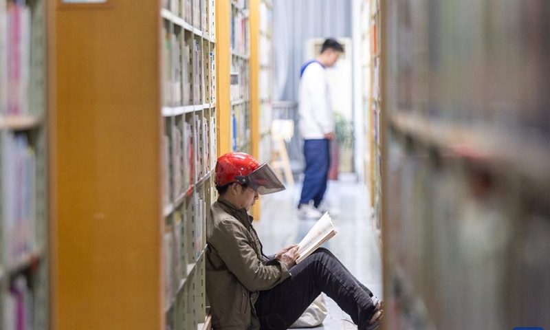 A man reads a book at a library during the May Day holiday in Huzhou City, east China's Zhejiang Province, May 1, 2023. (Photo by Yi Fan/Xinhua)