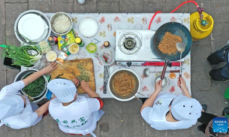 This aerial photo taken on May 8, 2023 shows chefs cooking local specialties during a culinary competition in Tianshi Township, Xianju County of Taizhou City, east China's Zhejiang Province. The culinary competition attracted many tourists to enjoy the delicacies.(Photo: Xinhua)