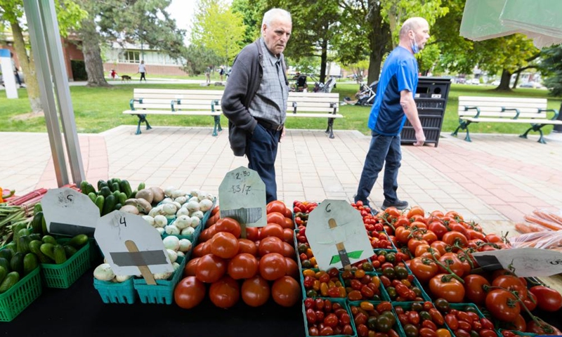 People walk past a stall at a farmers' market in Toronto, Canada, on May 16, 2023. Canada's Consumer Price Index (CPI) rose 4.4 percent year over year in April, following a 4.3 percent increase in March, Statistics Canada said Tuesday.(Photo: Xinhua)