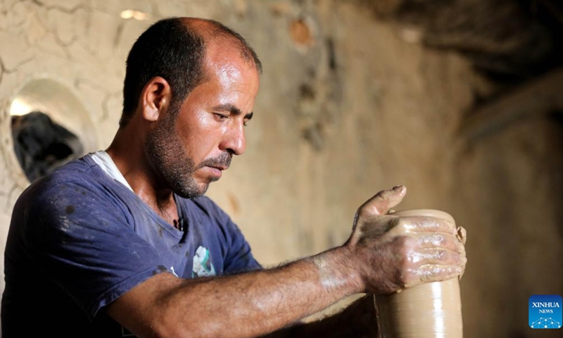 Safaa al-Kawaz, a pottery workshop owner, creates a piece of work in the Nahrawan area near Baghdad, Iraq, May 27, 2023. Pottery-making in Iraq has been an enduring profession which is deeply rooted in the civilizations of Mesopotamia. (Xinhua/Khalil Dawood)