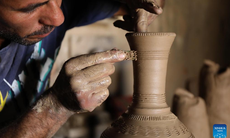 Safaa al-Kawaz, a pottery workshop owner, creates a piece of work in the Nahrawan area near Baghdad, Iraq, May 27, 2023. Pottery-making in Iraq has been an enduring profession which is deeply rooted in the civilizations of Mesopotamia. (Xinhua/Khalil Dawood)