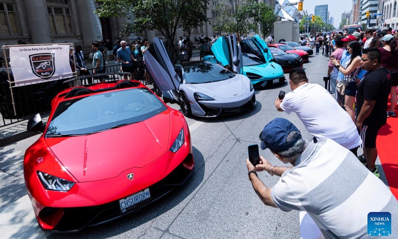 People visit the 2023 Yorkville Exotic Car Show in Toronto, Canada, on June 18, 2023. The annual event was held here on Sunday to celebrate Father's Day with about 100 cars on display. (Photo by Zou Zheng/Xinhua)