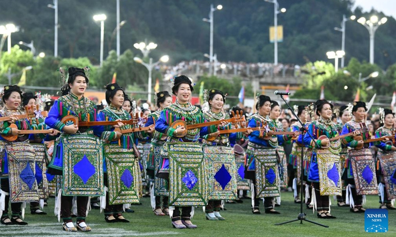 Villagers of Dong ethnic group wearing festive ethnic dress perform singing during the halftime of the Village Super League football match in Rongjiang County of southwest China's Guizhou Province, June 17, 2023. Villagers spontaneously wear ethnic dress and perform singing and dancing on every match day on weekends. (Xinhua/Yang Wenbin)