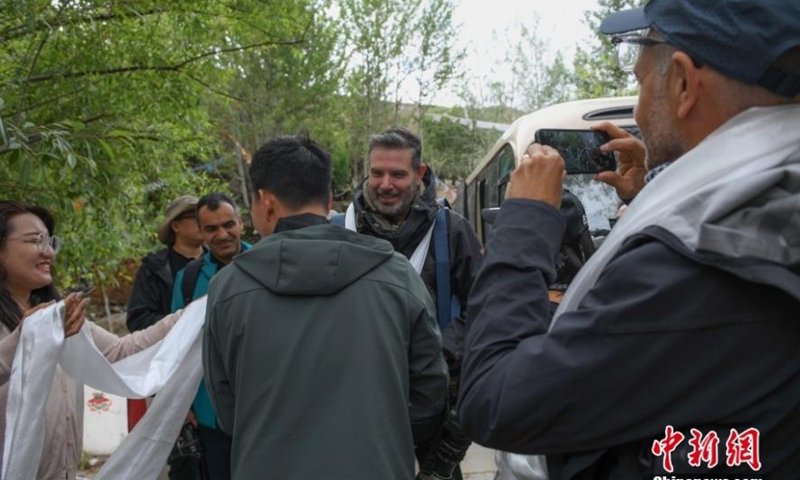 Villagers offer traditional white scarves known as hada to welcome a group of 20 journalists in Lhasa, southwest China's Tibet Autonomous Region, June 15, 2023. (Photo/China News Service)