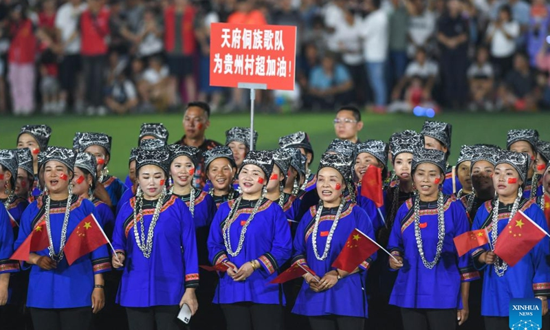 Villagers of Dong ethnic group wearing festive ethnic dress perform singing during the halftime of the Village Super League football match in Rongjiang County of southwest China's Guizhou Province, June 17, 2023. Villagers spontaneously wear ethnic dress and perform singing and dancing on every match day on weekends. (Xinhua/Yang Wenbin)