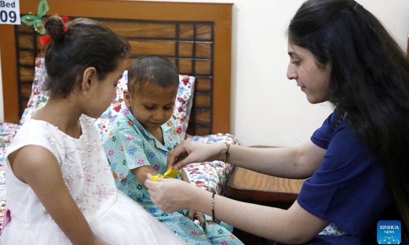 A nurse takes care of a girl at the China-funded compassionate home in Islamabad, Pakistan, May 28, 2023. A compassionate home formed by Chinese and Pakistani charity organizations was formally inaugurated here on Sunday to provide temporary accommodation for the relatives of children treated in hospitals for serious diseases.(Photo: Xinhua)