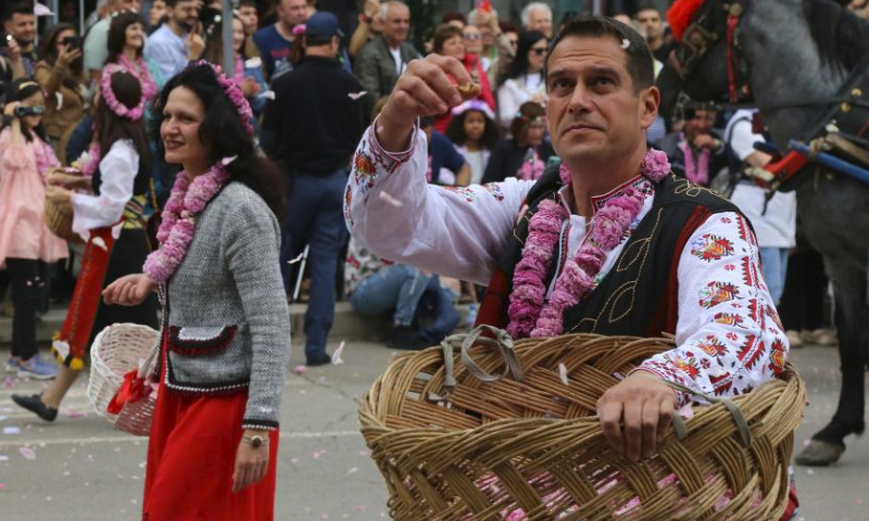 People in folk costumes toss rose petals in Kazanlak, Bulgaria, June 4, 2023. A parade took place here on Sunday during the 2023 Rose Festival. Kazanlak is known for its Rose Festival, which has been organized since 1903. (Xinhua/Lin Hao)