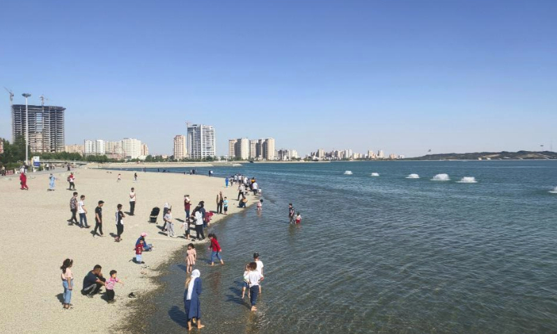 People have fun beside a lake at a park in Tehran, Iran, June 2, 2023. (Xinhua/Shadati)