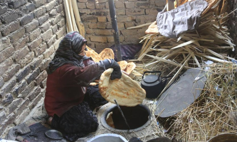 A woman bakes naan, Afghan traditional flatbread, in Kabul, Afghanistan, June 4, 2023. (Photo by Saifurahman Safi/Xinhua)