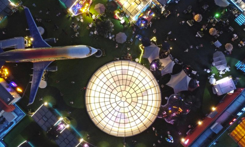 This photo taken on June 2, 2023 shows people having fun on top of a commercial complex in Heping District, north China's Tianjin. Transformed from four vacant buildings, a commercial complex was unveiled in Heping District of Tianjin recently. This commercial complex not only offers people with shopping malls but also leisure spaces such as rooftop parks and pocket parks. The airplane themed bar and other entertainment spaces located on top of the commercial complex gained popularity for the surrounding business area. (Xinhua/Li Ran)