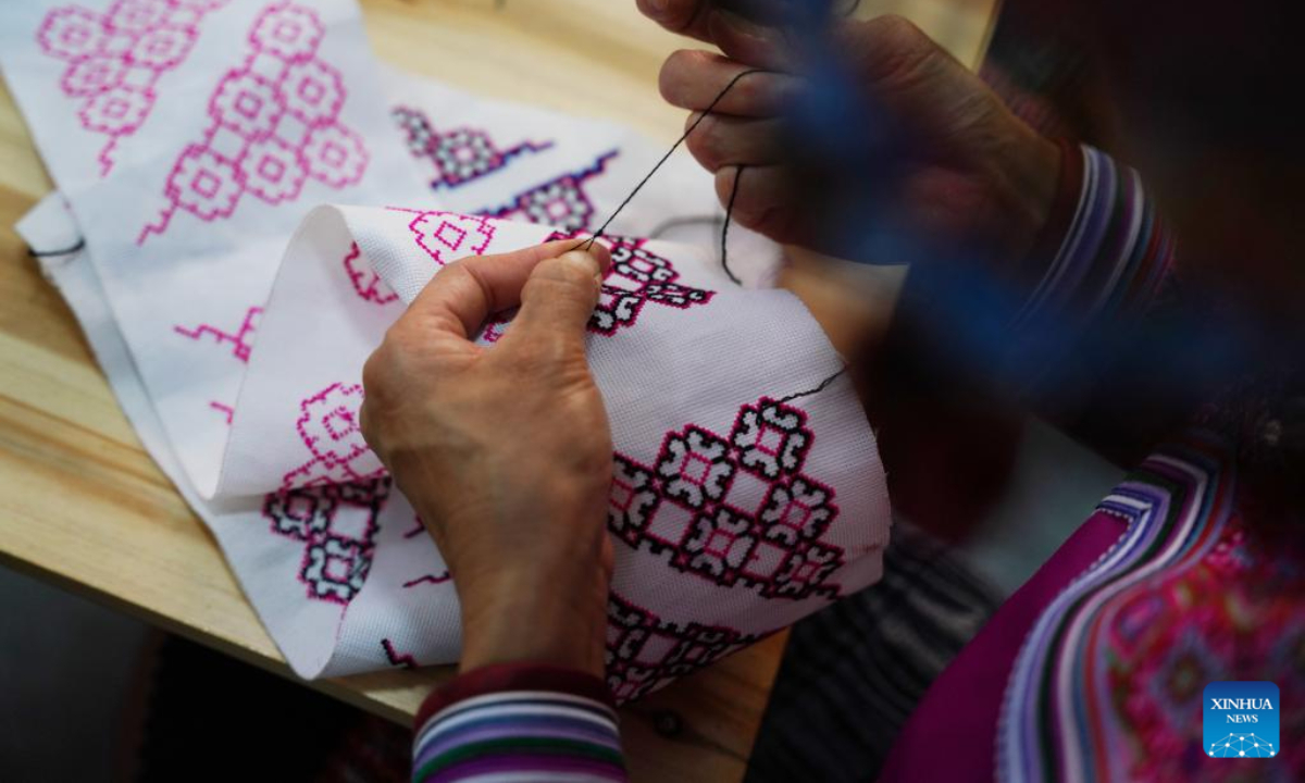 A woman of Miao ethnic group makes embroidery works at a workshop in Pingbian Miao Autonomous County, southwest China's Yunnan Province, June 1, 2023. Pingbian Miao Autonomous County has been making efforts to support and develop its embroidery industry, trying to provide job opportunities to local women. Photo:Xinhua