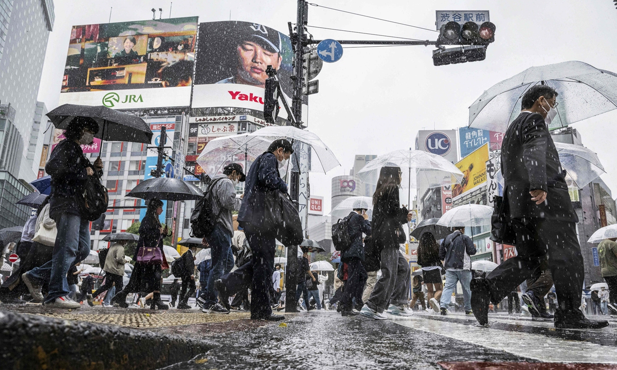 People use their umbrellas to shelter from the rain as they walk through Shibuya district in Tokyo on June 2, 2023. Photo: VCG