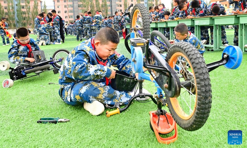 Children repair bikes during a themed event in Erdos, north China's Inner Mongolia Autonomous Region, May 31, 2023. June 1 marks the International Children's Day. Various events were held nationwide with vibrant colors and joyful laughter as children and families gathered for celebration.(Photo: Xinhua)