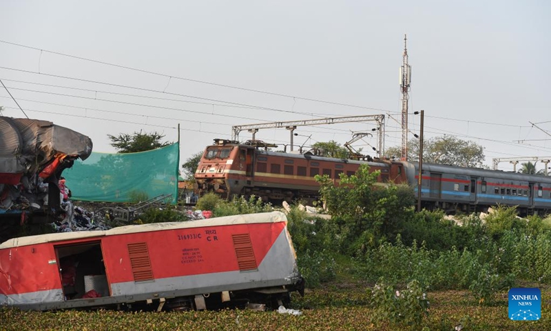 A passenger train passes by the site of a triple-train crash in Balasore district of the eastern Indian state of Odisha, June 5, 2023. Normal rail traffic has resumed both ways at the site where the triple-train crash had occurred on Friday in India's eastern state of Odisha, claiming 275 human lives, announced the federal Ministry of Railways on Monday.(Photo: Xinhua)