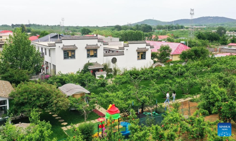 This aerial photo taken on June 5, 2023 shows guests visiting the orchard of a high-end homestay in Feishizhuang Village, Qinhuangdao, north China's Hebei Province. Qinhuangdao, widely noted for its seaside tourist attractions, has pinned much importance to the development of homestay service in a way to accelerate the growth in its rural areas. To date, there are more than 2,200 homestays in operation in the region.(Photo: Xinhua)