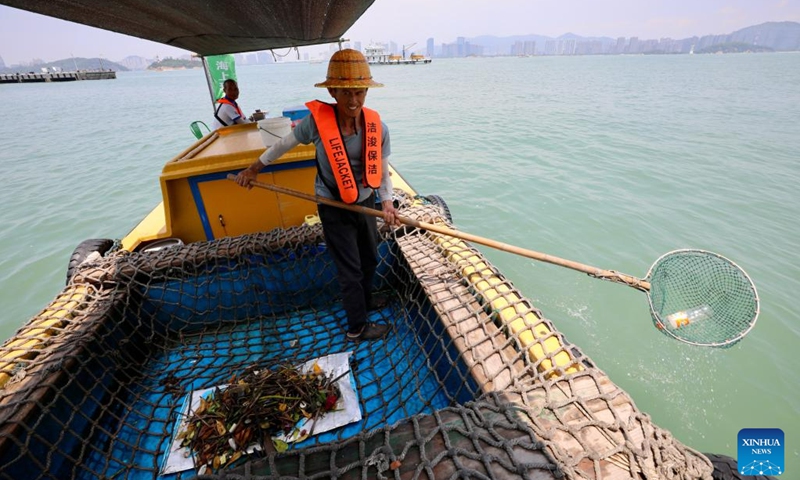 A sanitation worker collects stray waste from the ocean in Xiamen, southeast China's Fujian Province, June 4, 2023. Founded in 1994, the ocean sanitation station in Xiamen has been dedicated to the removal of marine waste and is now equipped with four sanitation docks, six mechanical sanitation vessels, 48 sanitation boats and more than 160 staff members. (Photo: Xinhua)