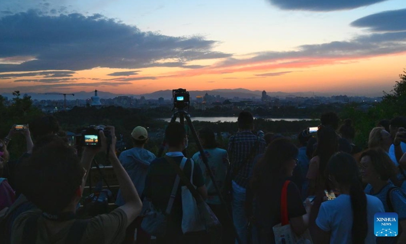 Tourists take photos of Beihai Park at Jingshan Park in Beijing, capital of China, June 7, 2023.(Photo: Xinhua)