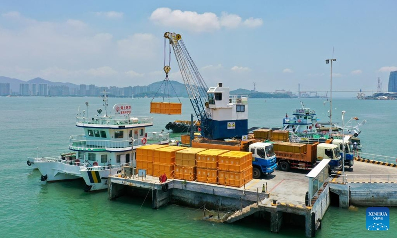 This aerial photo shows containers loaded with stray waste being conveyed from a sanitation vessel to a sanitation dock in Xiamen, southeast China's Fujian Province, June 4, 2023. Founded in 1994, the ocean sanitation station in Xiamen has been dedicated to the removal of marine waste and is now equipped with four sanitation docks, six mechanical sanitation vessels, 48 sanitation boats and more than 160 staff members.(Photo: Xinhua)