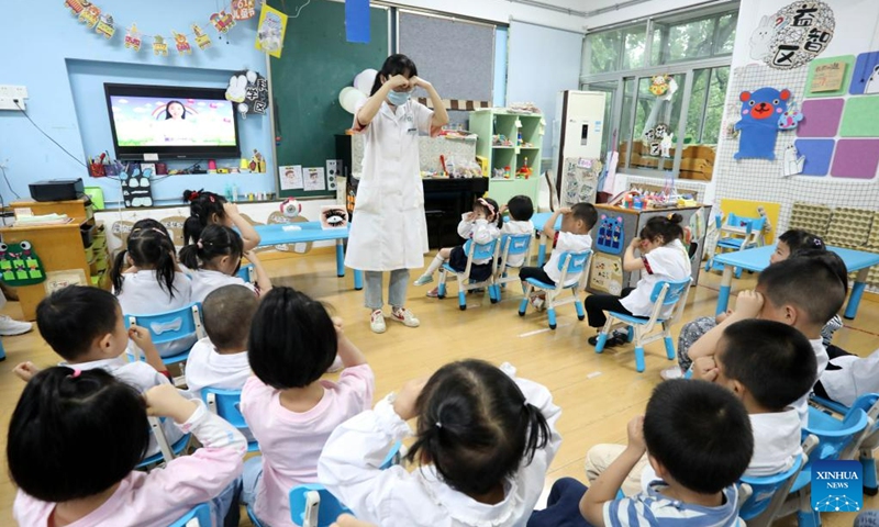 A medical worker guides children to do eye exercises at a kindergarten in Suzhou, east China's Jiangsu Province, June 5, 2023. Various activities themed on eye caring were held at schools across the country ahead of the National Eye Care Day, which falls on June 6.(Photo: Xinhua)