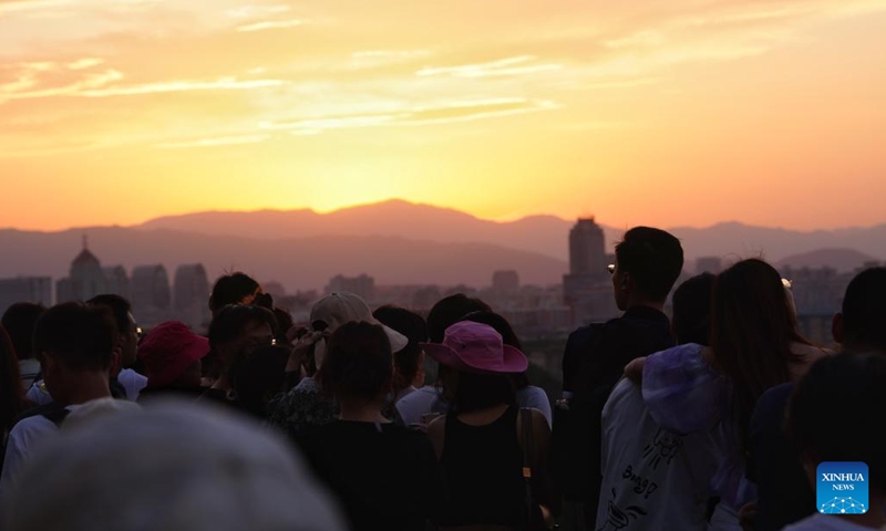 Tourists watch the sunset at Jingshan Park in Beijing, capital of China, on June 7, 2023(Photo: Xinhua)