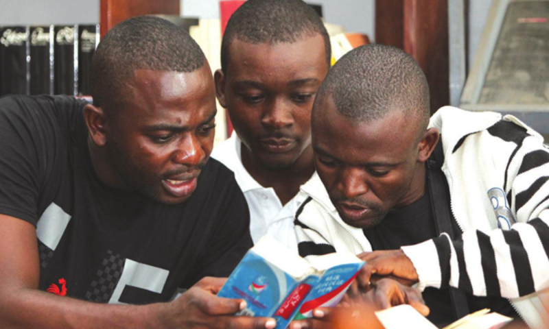 In Brazzaville, the capital of the Republic of the Congo, students at the Confucius Institute of the Marien Ngouabi University are looking up words in a dictionary before their Chinese class. Photo by Meng Chenguang/Xinhua)