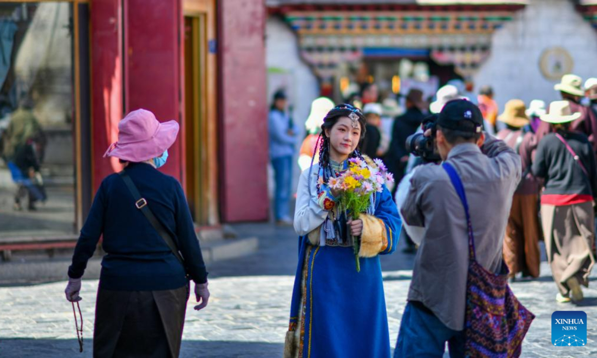 A tourist in traditional Tibetan costume poses for photos in Lhasa, southwest China's Tibet Autonomous Region, June 6, 2023. Photo:Xinhua